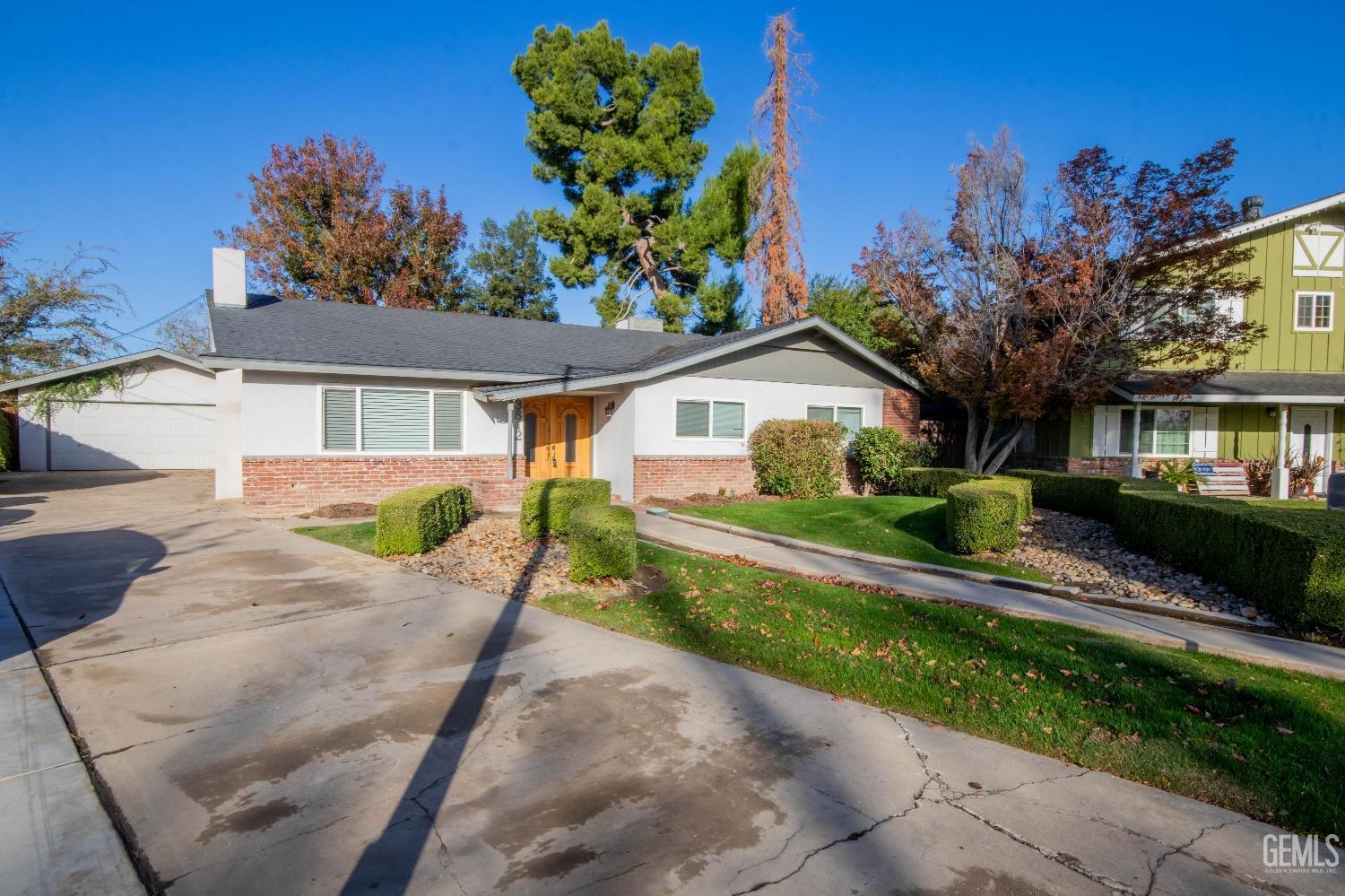 Undisclosed Address Bakersfield, CA 93309 - Photo 3 of 39 a front view of a house with a porch and a yard
