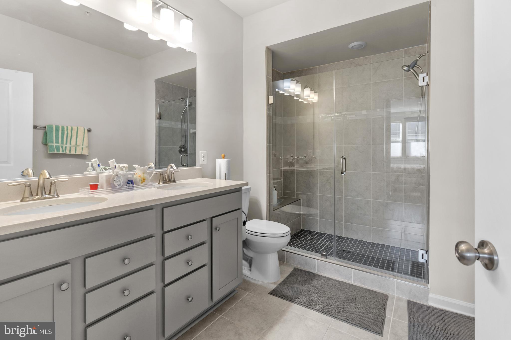 12129 American Chestnut Road Bowie, MD 20720 - Photo 14 of 25 a bathroom with a double vanity sink toilet and shower