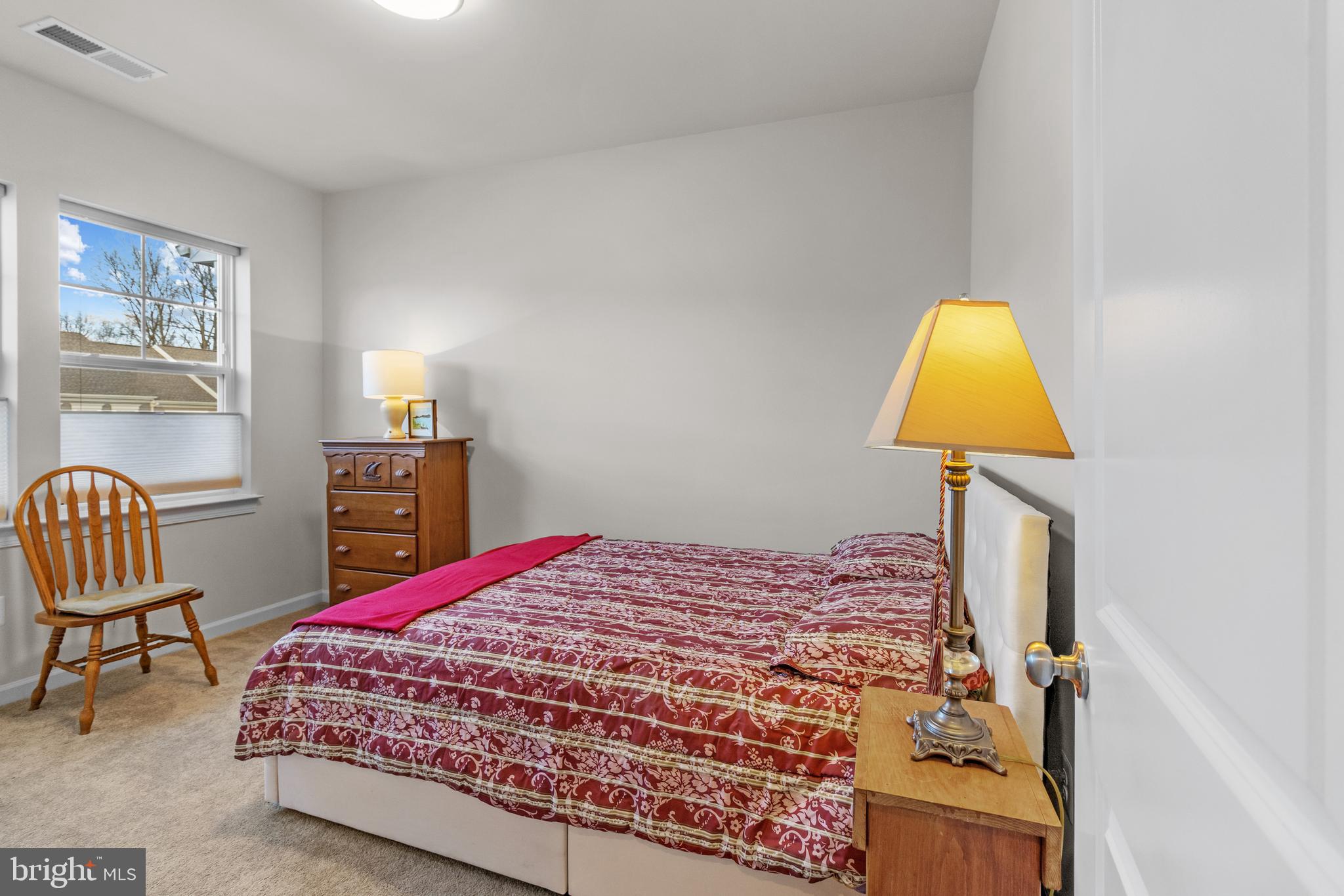 12129 American Chestnut Road Bowie, MD 20720 - Photo 18 of 25 a bedroom with a bed chair and a lamp on dresser