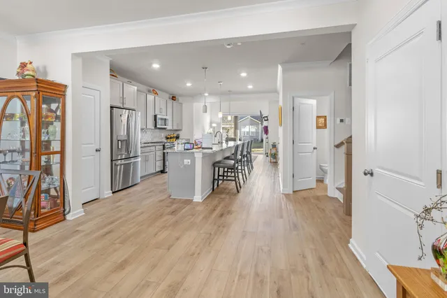 a view of a kitchen with refrigerator and wooden floor