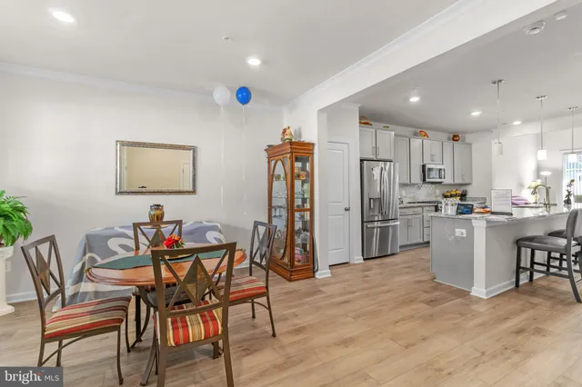 a kitchen with refrigerator and chairs