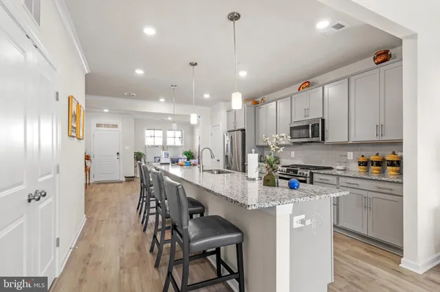 a kitchen with kitchen island white cabinets and stainless steel appliances