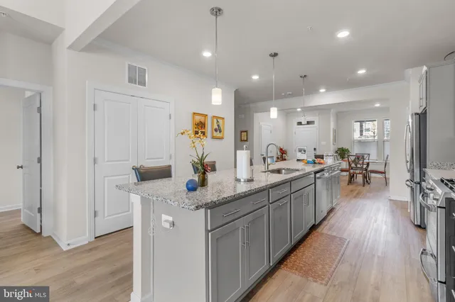 a kitchen with stainless steel appliances granite countertop lots of counter top space and wooden floor