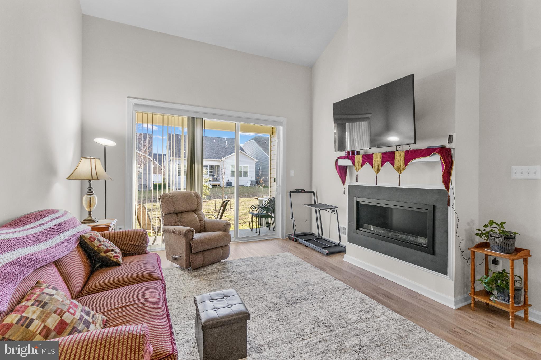 12129 American Chestnut Road Bowie, MD 20720 - Photo 9 of 25 a living room with furniture a flat screen tv and a fireplace