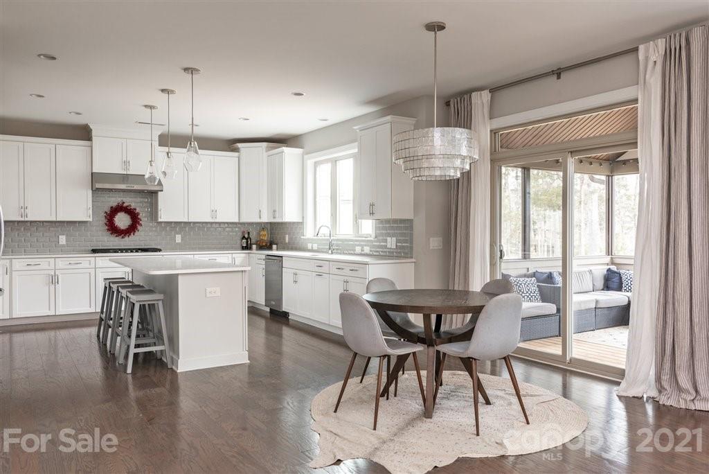 4000 Flowering Peach Road Marvin, NC 28173 - Photo 11 of 48 a kitchen with stainless steel appliances kitchen island granite countertop a dining table chairs and white cabinets