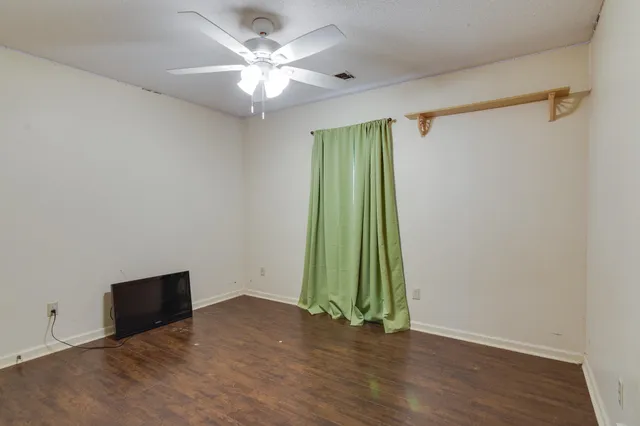 a view of an empty room with a fan and a window