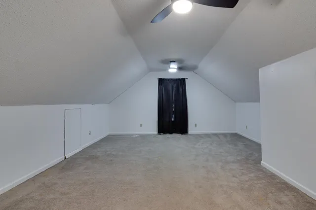 an empty room with a chandelier fan