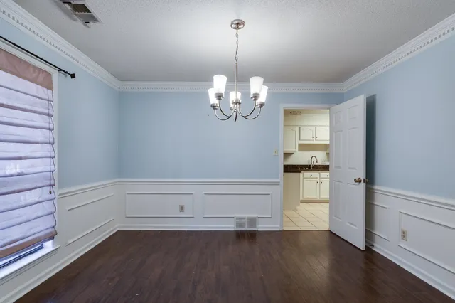 a view of a room with wooden floor and chandelier