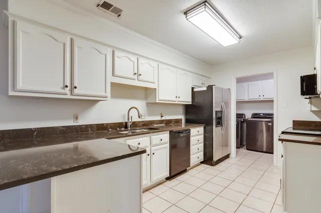 a kitchen with stainless steel appliances granite countertop a refrigerator sink and stove