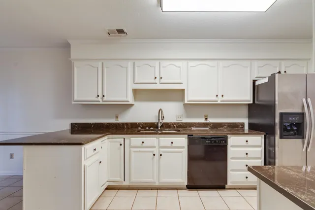 a kitchen with granite countertop white cabinets and stainless steel appliances