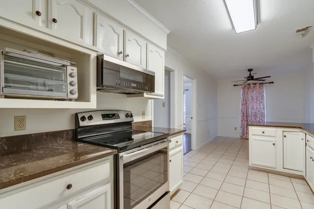 a kitchen with granite countertop a stove sink and cabinets