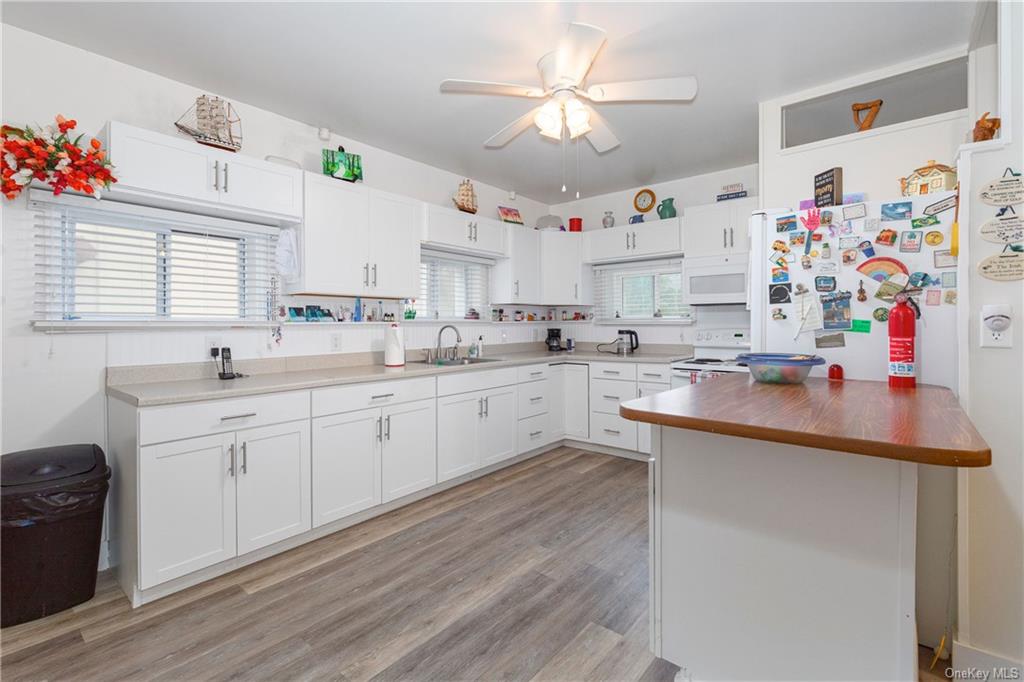 1030 Highway 199 Red Hook, NY 12571 - Photo 2 of 30 Kitchen featuring ceiling fan, sink, white appliances, white cabinetry, and light wood-type flooring