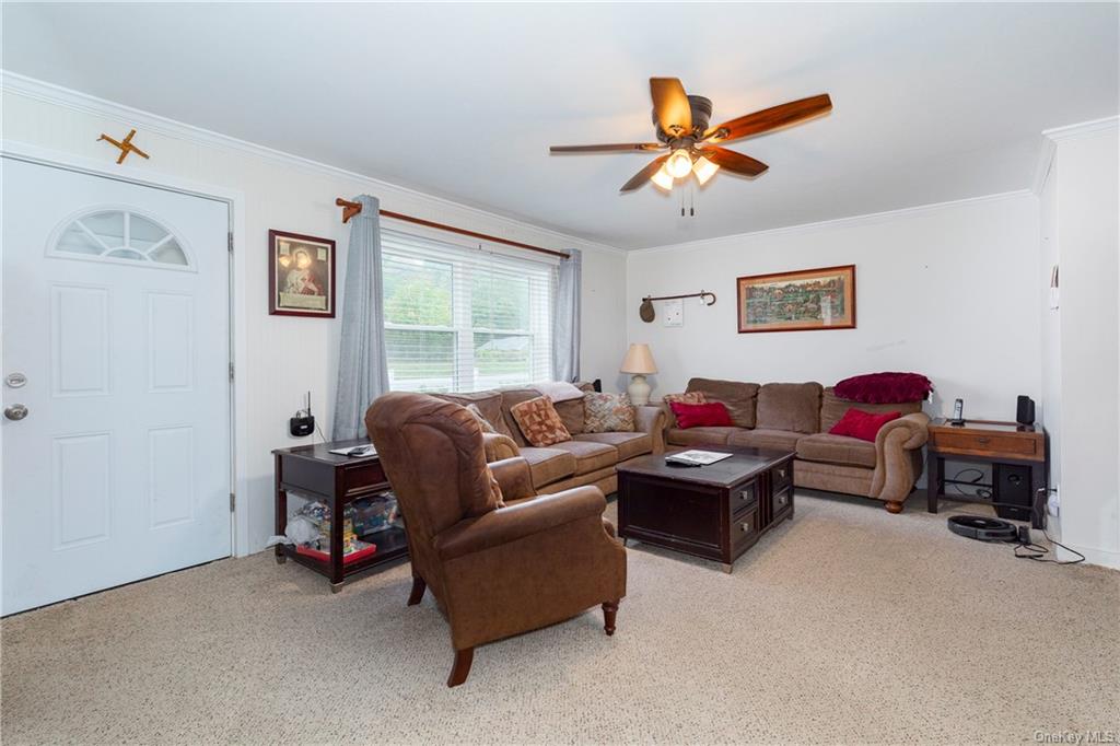 1030 Highway 199 Red Hook, NY 12571 - Photo 5 of 30 Carpeted living room featuring ornamental molding and ceiling fan