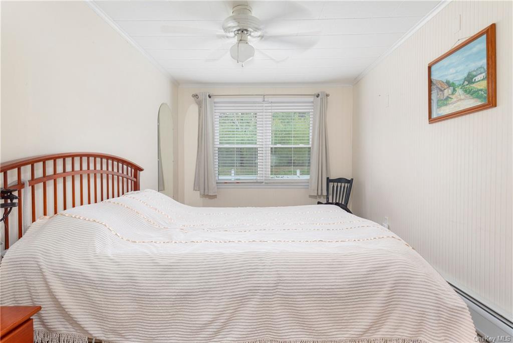 1030 Highway 199 Red Hook, NY 12571 - Photo 6 of 30 Bedroom with ceiling fan, crown molding, and a baseboard heating unit
