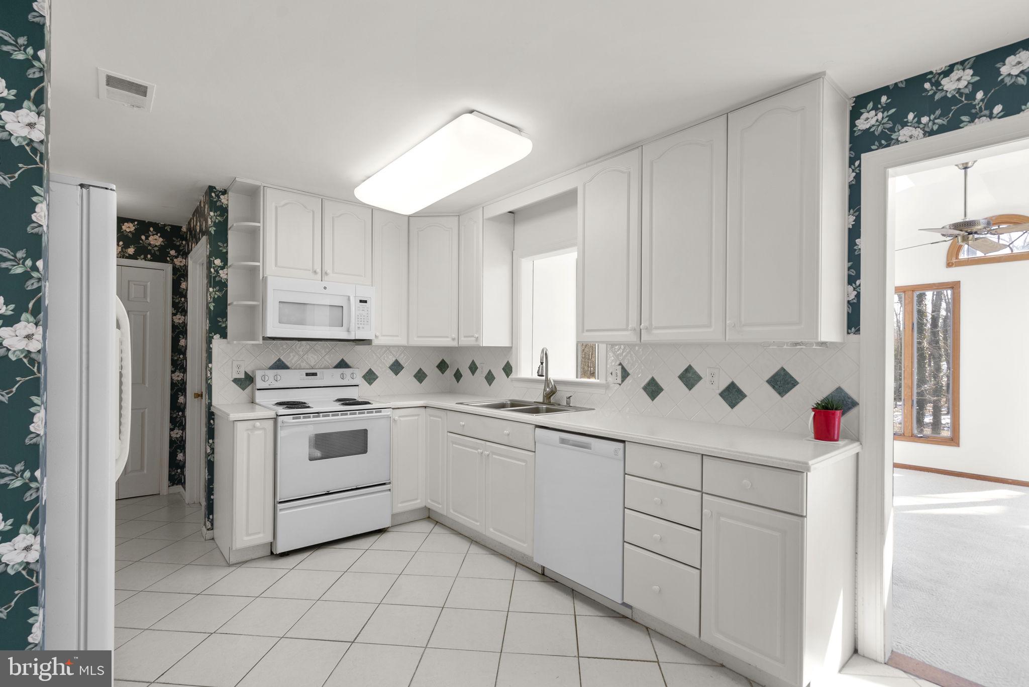 4404 Rendale Court Olney, MD 20832 - Photo 3 of 32 a kitchen with white cabinets and white appliances