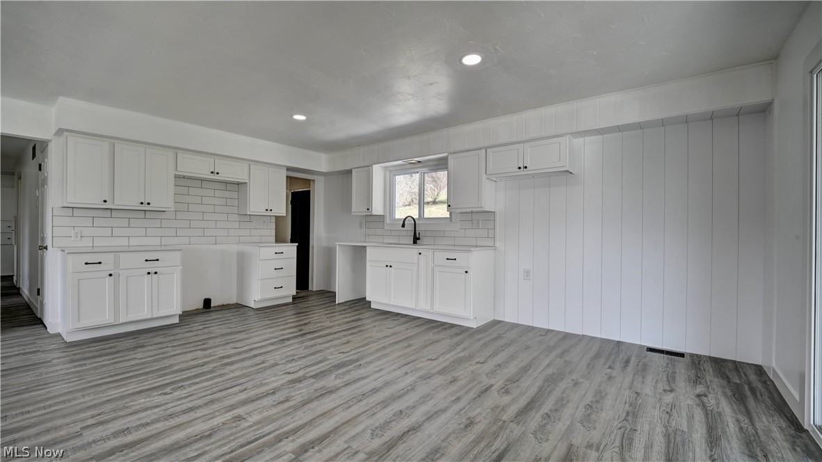 3265 York View Road Southwest New Philadelphia, OH 44663 - Photo 21 of 45 Kitchen with white cabinets, light countertops, backsplash, light wood-type flooring, and recessed lighting