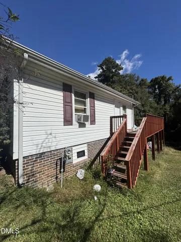 a backyard of a house with wooden floor and outdoor seating