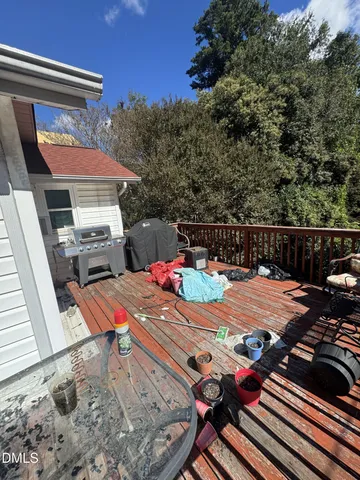 a view of a patio with table and chairs with wooden floor and fence