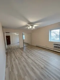 a view of empty room with wooden floor