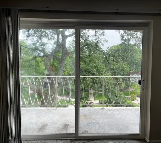 a view of a room with a large window and wooden floor
