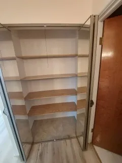 an empty room with wooden floor and cabinet