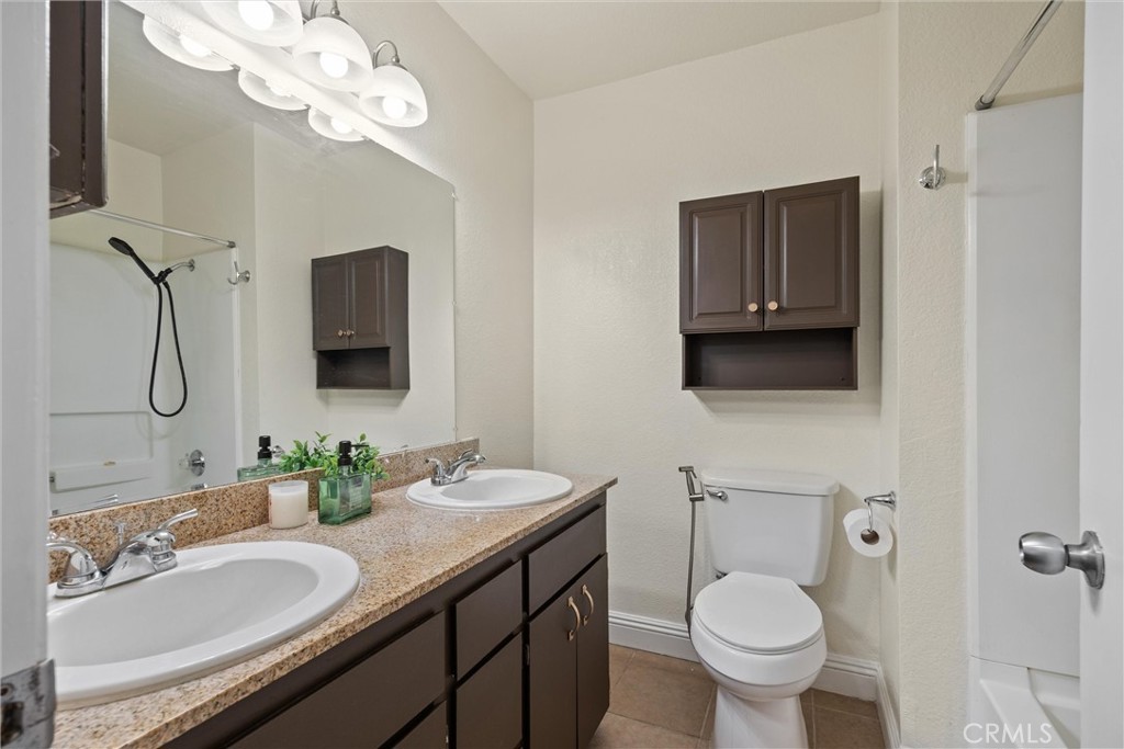 2055 Amanda Way, Unit 29 Chico, CA 95928 - Photo 14 of 19 a bathroom with a granite countertop toilet sink and mirror
