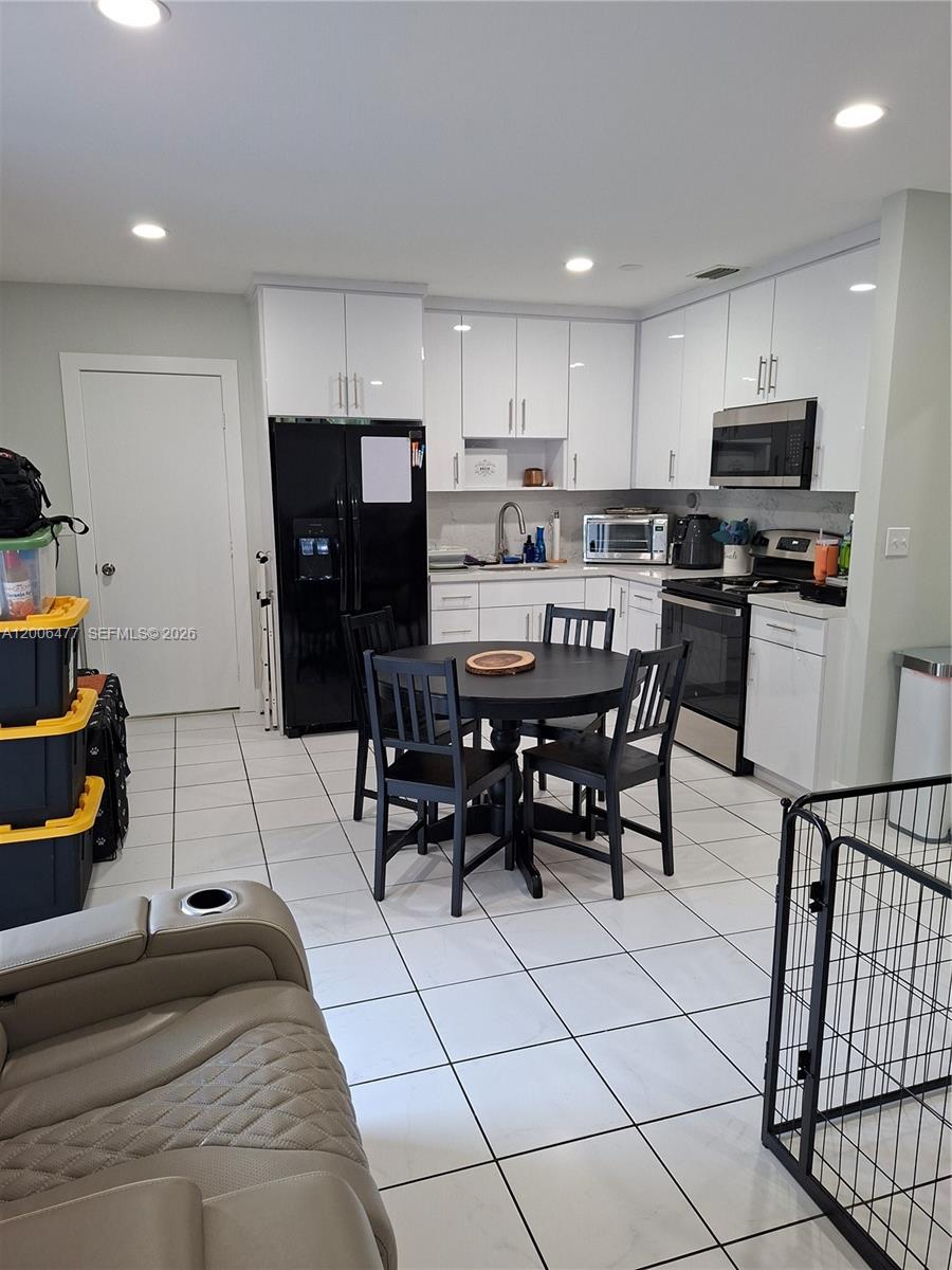 1814 Southwest 97th Terrace, Unit A Miramar, FL 33025 - Photo 9 of 9 a kitchen with stainless steel appliances kitchen island granite countertop a table and chairs in it