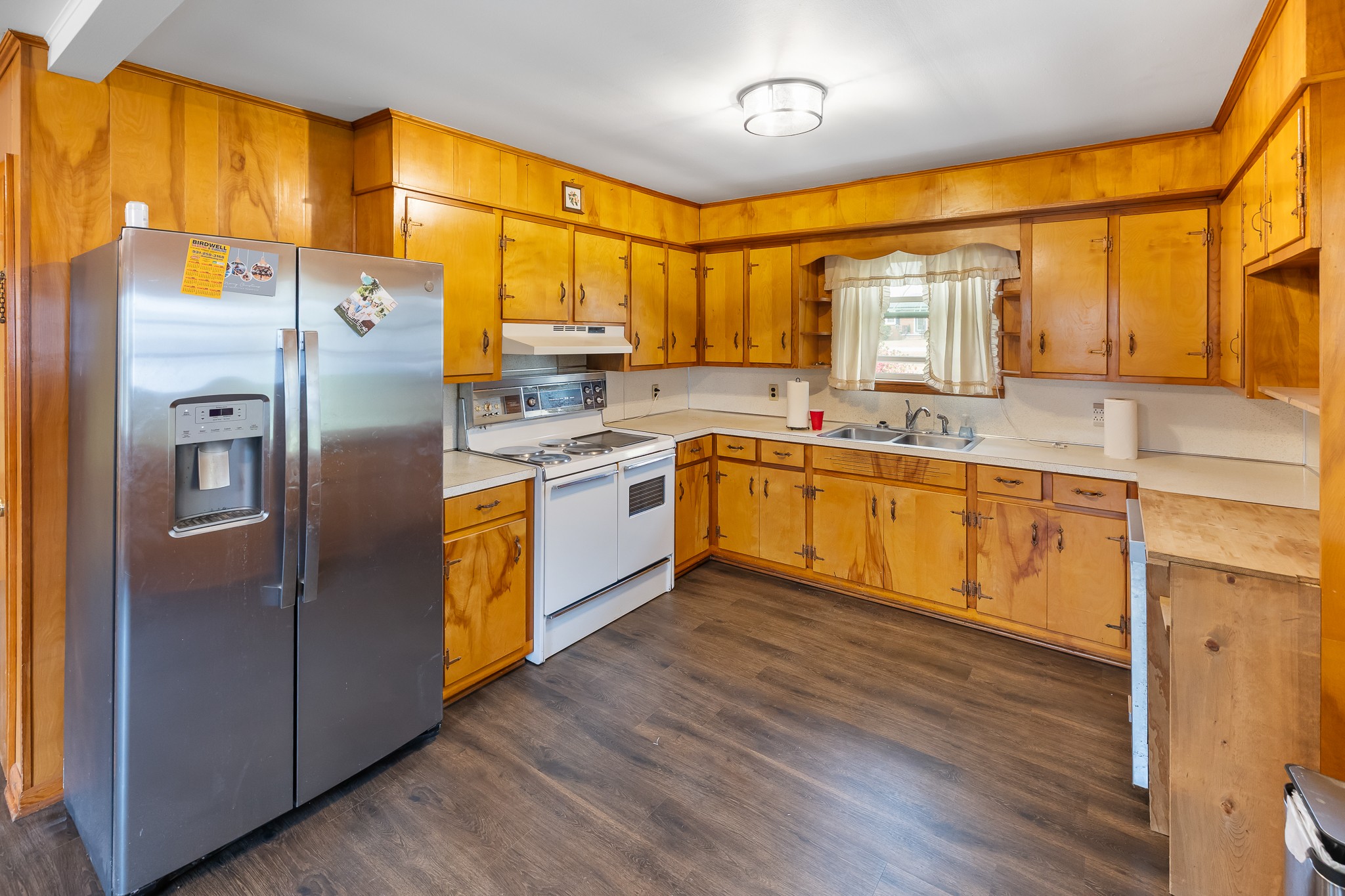111 Cothron Drive Lafayette, TN 37083 - Photo 15 of 33 a kitchen with stainless steel appliances granite countertop a refrigerator a sink dishwasher a stove with wooden cabinets and floor