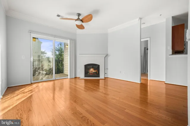 a view of an empty room with a fireplace and a window