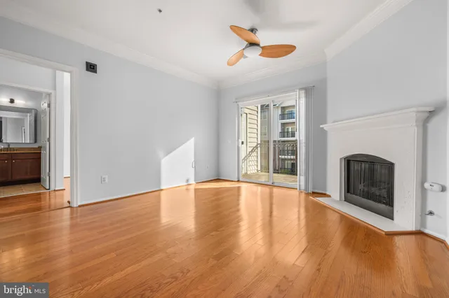 an empty room with wooden floor a fireplace and windows