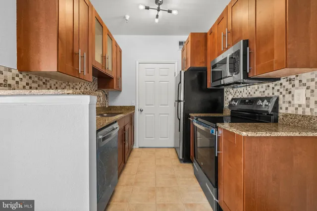 a kitchen with stainless steel appliances granite countertop a refrigerator a stove top oven a sink and dishwasher