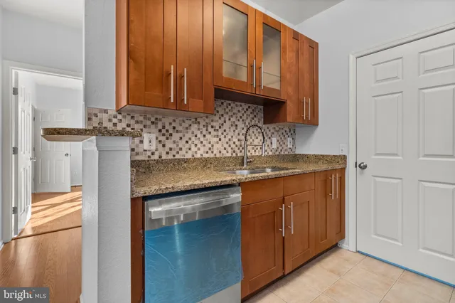 a kitchen with granite countertop wooden cabinets and a sink
