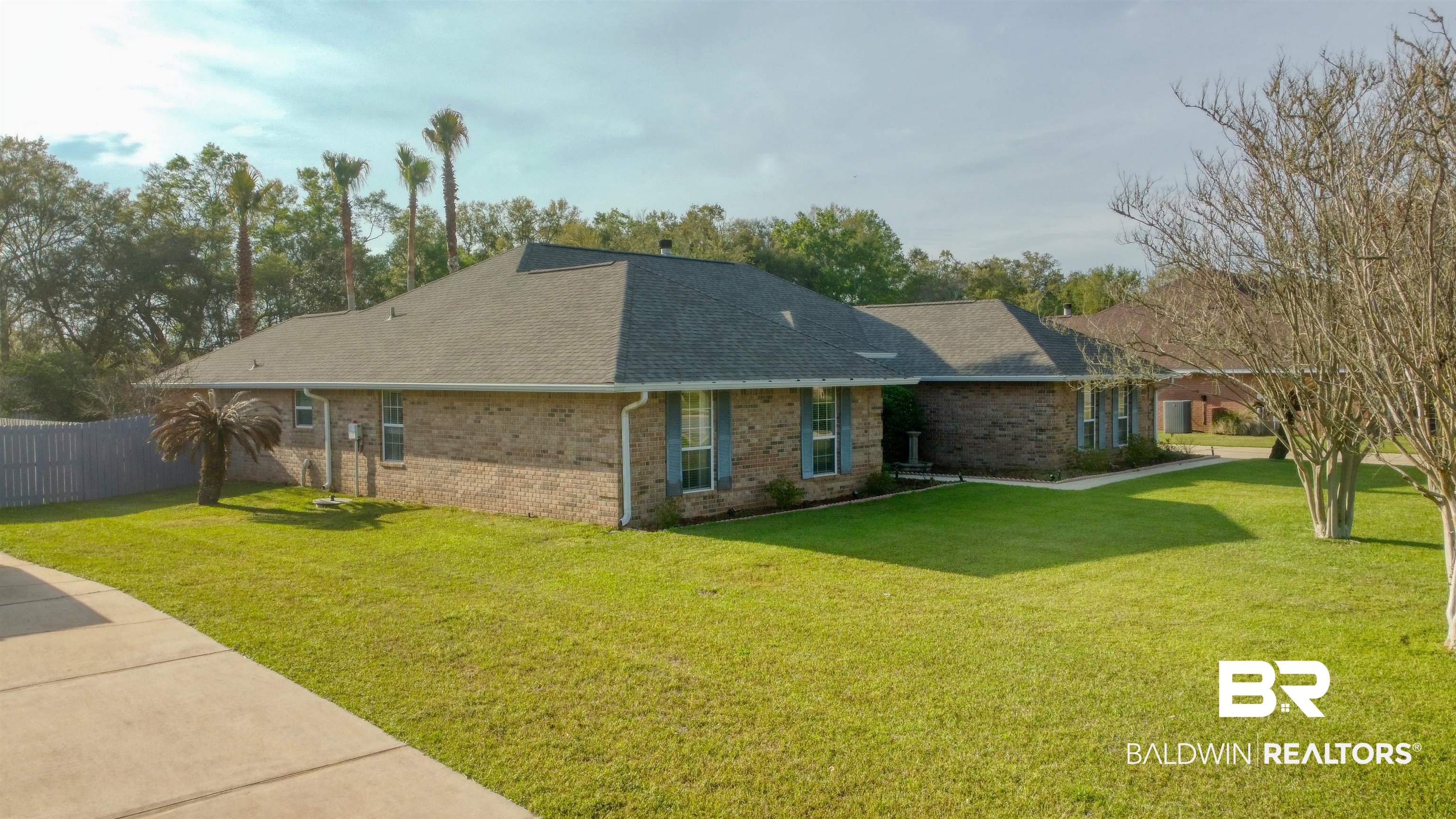 12893 Hunters Chase Foley, AL 36535 - Photo 2 of 42 Exterior space featuring roof with shingles, fence, brick siding, and a yard