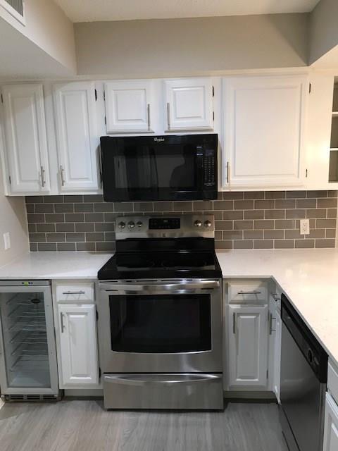 18240 Midway Road, Unit 303 Dallas, TX 75287 - Photo 4 of 22 a kitchen with granite countertop a stove top oven microwave and cabinets