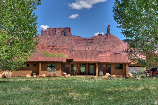 425 Amber Lane Moab, UT 84532 - Photo 22 of 27 Back of property featuring stucco siding, a yard, and a metal roof