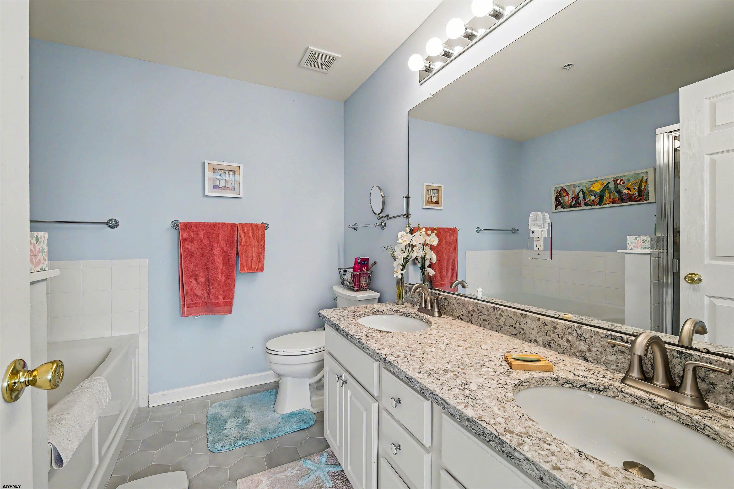 35 Bayside Drive, Unit 35 Somers Point, NJ 08244 - Photo 23 of 40 a bathroom with a granite countertop sink a toilet and a shower curtain