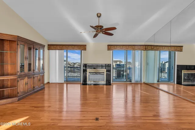 a view of a livingroom with wooden floor and a ceiling fan