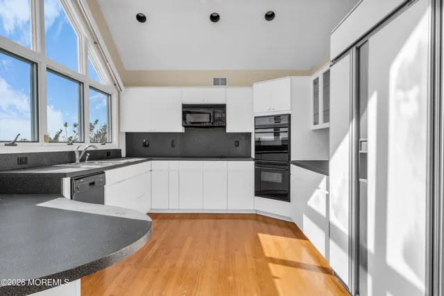 a kitchen with stainless steel appliances granite countertop a refrigerator and a stove