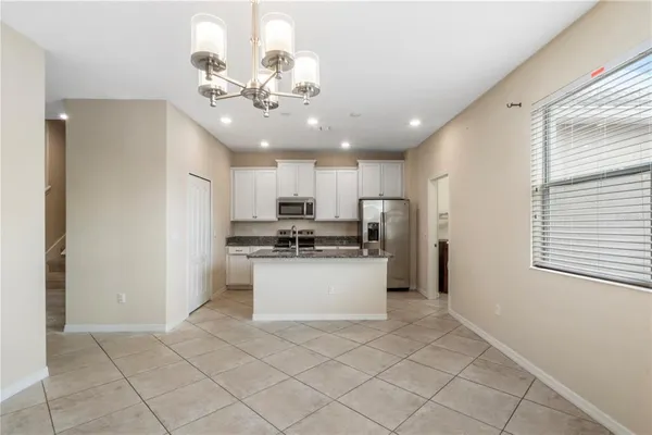 a kitchen with stainless steel appliances kitchen island granite countertop a refrigerator and a sink