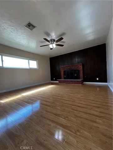a view of an empty room with a fireplace and a window