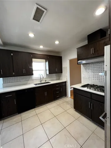 a large kitchen with granite countertop a stove and a sink