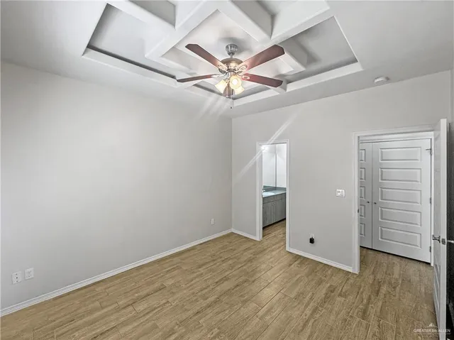 an empty room with a ceiling fan and wooden floor