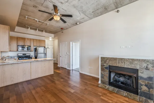 a large kitchen with cabinets wooden floor and a fireplace