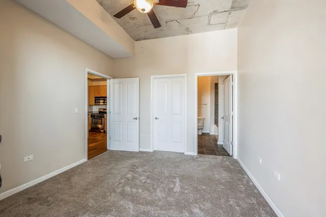 an empty room with closet and a chandelier fan