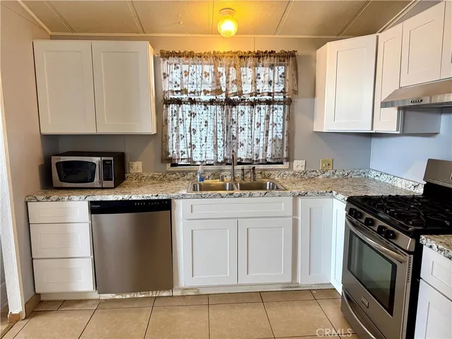 a kitchen with stainless steel appliances granite countertop a stove sink and microwave