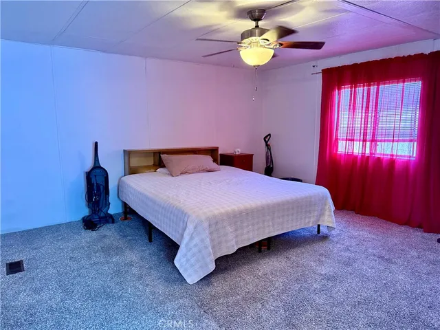 a spacious bedroom with a bed and a chandelier