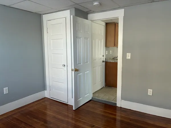 an empty room with wooden floor and entrance