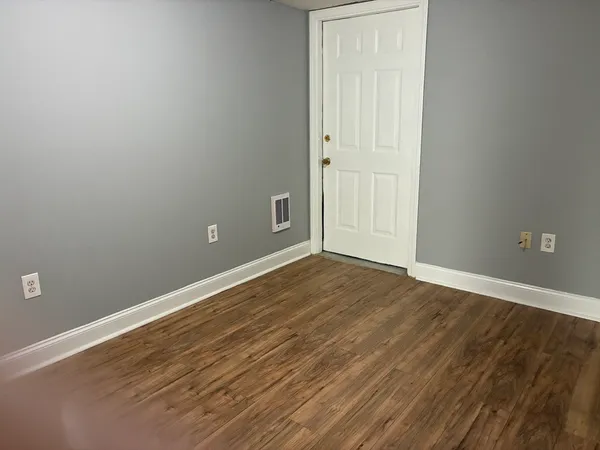 an empty room with wooden floor and closet