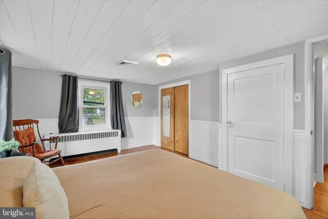 a view of a bedroom with furniture and window