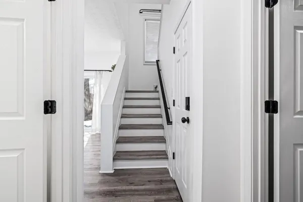 a view of a hallway with a white walls and stairs